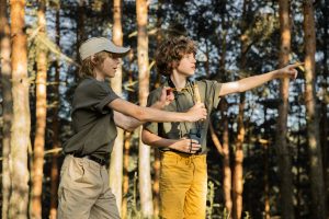 children practicing slingshot target shooting to improve focus and coordination outdoors
